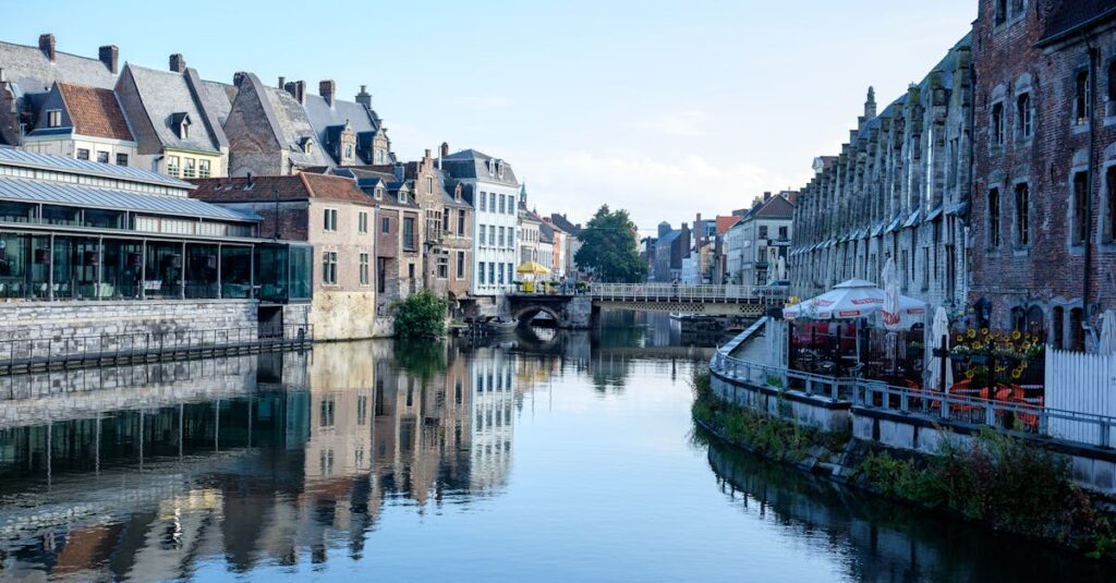 Picturesque canal scene in Ghent, Belgium, showcasing historic architecture and tranquil reflections.