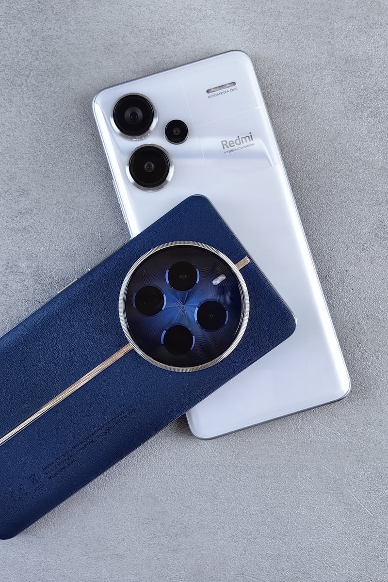 Close-up of two smartphones with unique designs on a minimalist surface, showcasing sleek technology.